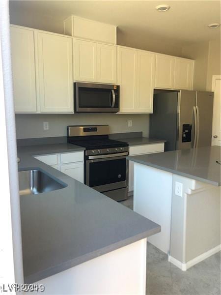 kitchen featuring appliances with stainless steel finishes, a sink, white cabinets, and recessed lighting