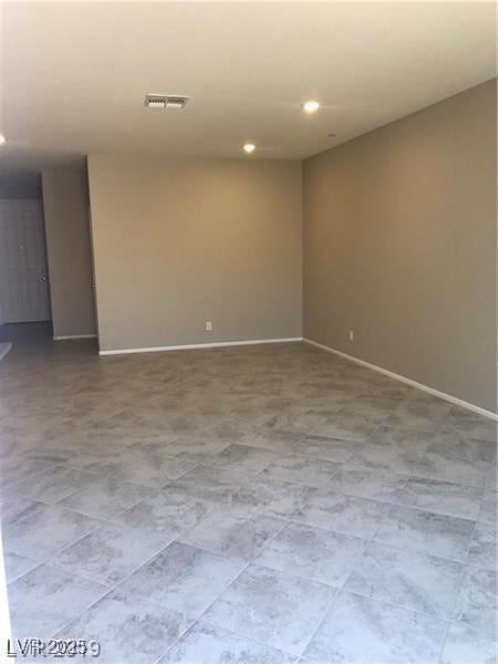 empty room featuring baseboards and recessed lighting