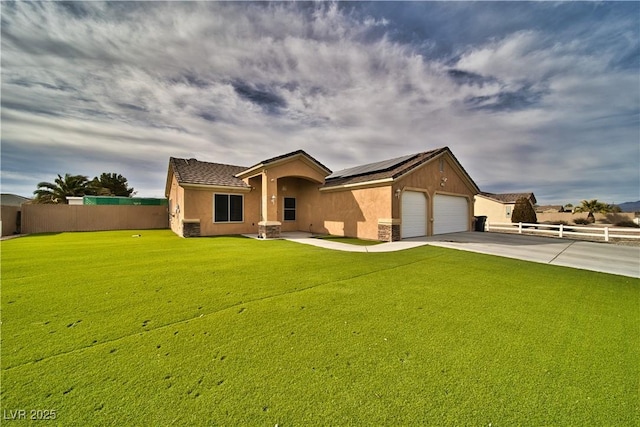 view of front of house with a garage, a front lawn, and solar panels