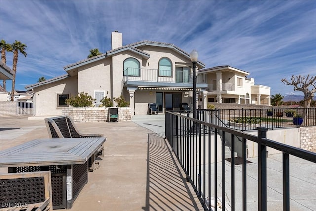 back of house featuring a balcony and a patio