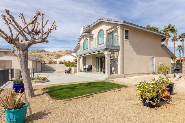 back of property with a balcony and a patio area