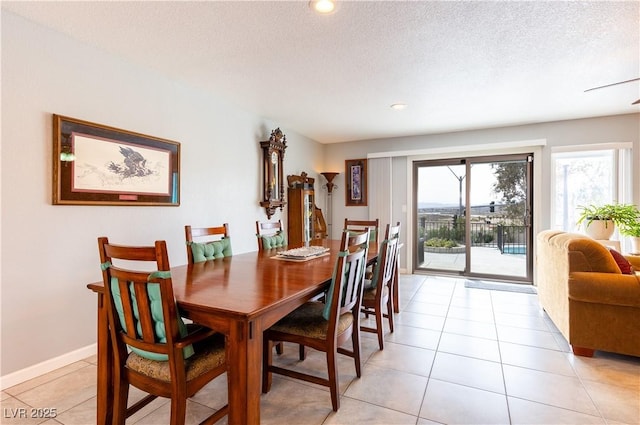 dining area with light tile patterned flooring and a textured ceiling