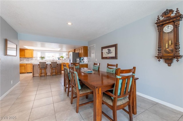 tiled dining space featuring a textured ceiling