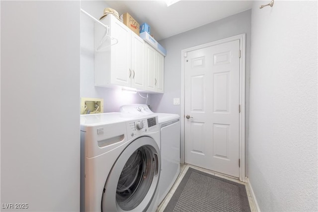 laundry room featuring separate washer and dryer and cabinets