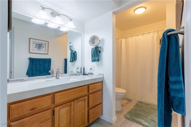 bathroom featuring vanity, wood-type flooring, and toilet