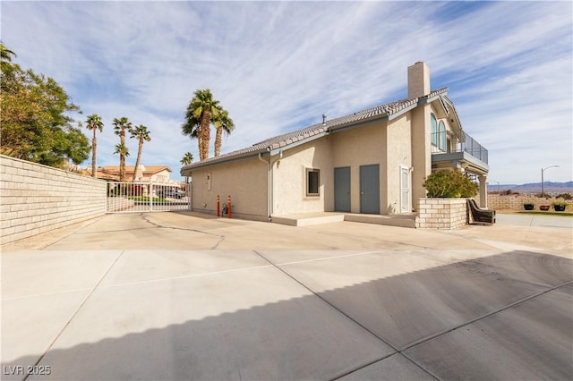 rear view of property featuring a balcony and a patio area