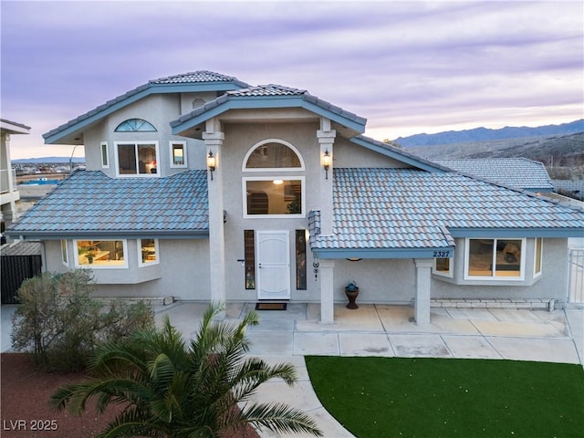 view of front of property featuring a mountain view and a patio area