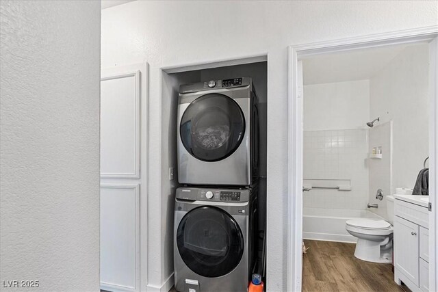 4730 E Craig Rd Unit 1172, Las Vegas, NV 89115 - washroom featuring estacked washer and dryer, wood finished floors, and a textured wall