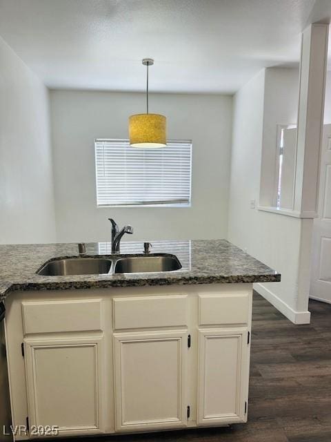 4730 E Craig Rd Unit 1172, Las Vegas, NV 89115 - kitchen featuring a sink, dark wood-style floors, decorative light fixtures, dark stone countertops, and baseboards