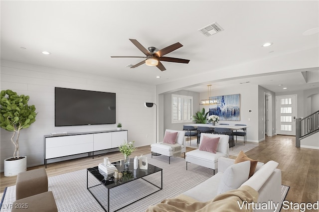 living room featuring light hardwood / wood-style flooring and ceiling fan