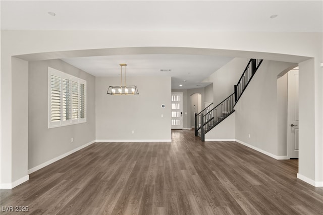 interior space featuring an inviting chandelier, plenty of natural light, and dark hardwood / wood-style floors