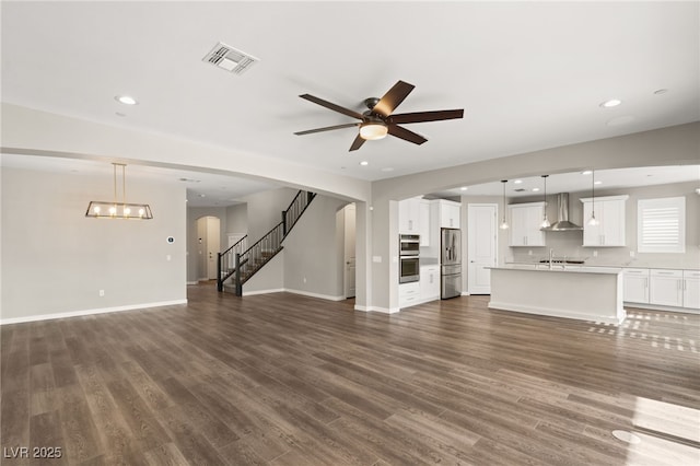 unfurnished living room with ceiling fan and dark hardwood / wood-style floors