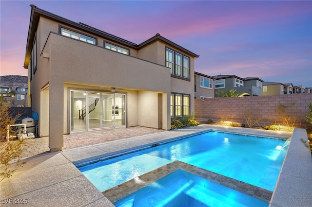 pool at dusk featuring a patio area