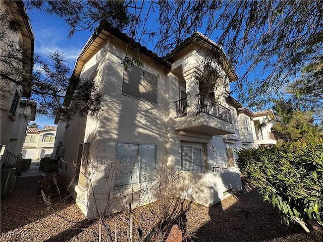 view of front of house with a balcony and stucco siding