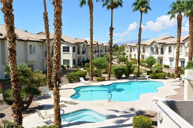 community pool featuring a patio area, a residential view, and fence