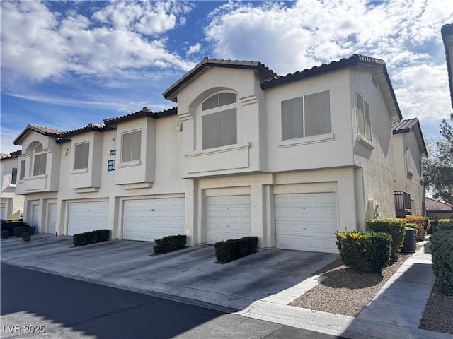 view of front of house with a garage, driveway, cooling unit, and stucco siding