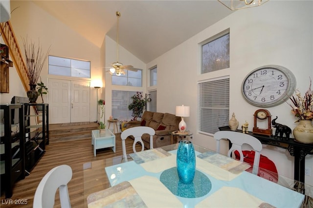 dining room with hardwood / wood-style flooring, ceiling fan, and high vaulted ceiling