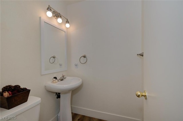 bathroom with hardwood / wood-style flooring, sink, and toilet