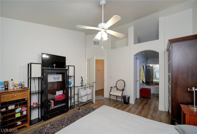 bedroom featuring ceiling fan, dark hardwood / wood-style flooring, and a high ceiling