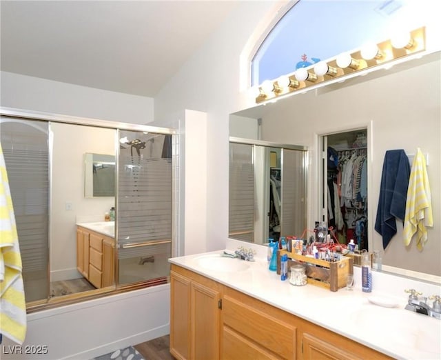 bathroom featuring vanity, wood-type flooring, and shower / bath combination with glass door