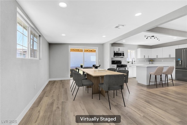 dining area featuring sink and light hardwood / wood-style flooring