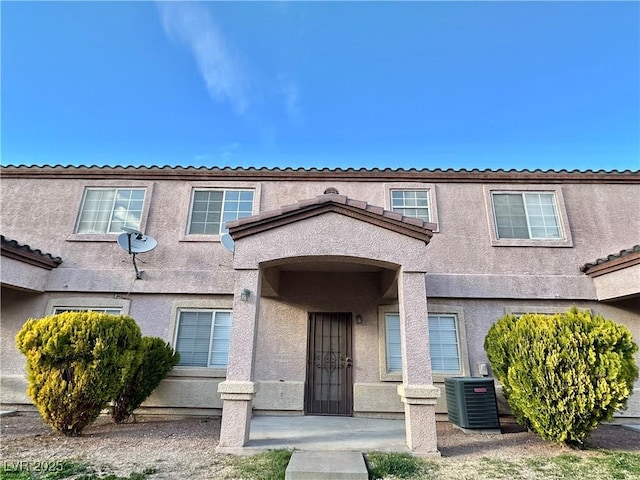 townhome / multi-family property with stucco siding and central air condition unit