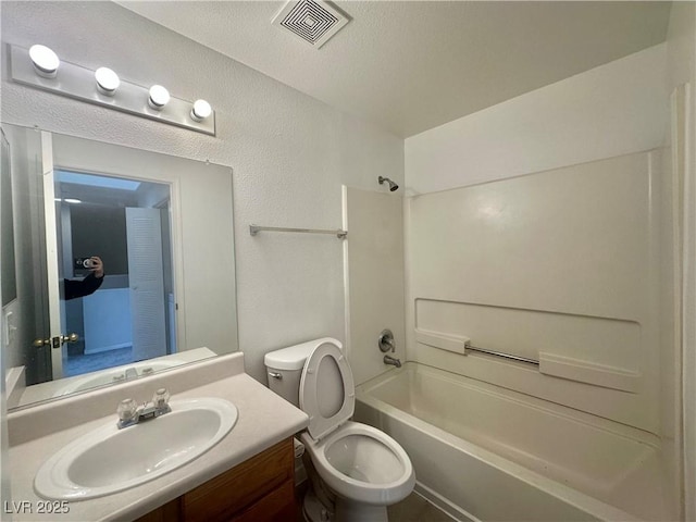 full bath with a textured wall, bathtub / shower combination, toilet, vanity, and visible vents