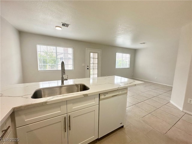 kitchen featuring light stone counters, visible vents, a sink, a textured ceiling, and dishwasher