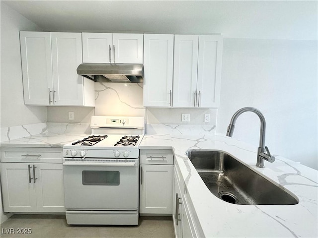 kitchen featuring a sink, under cabinet range hood, light stone counters, and gas range gas stove