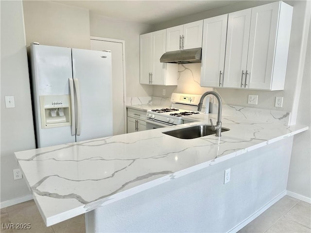 kitchen featuring white appliances, a sink, under cabinet range hood, and light stone countertops