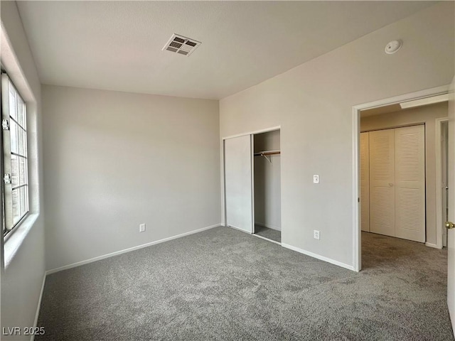 unfurnished bedroom with carpet floors, a closet, visible vents, and baseboards