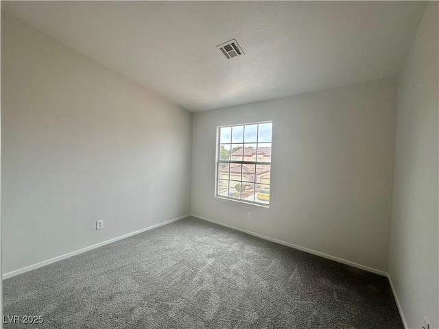 carpeted spare room featuring visible vents and baseboards