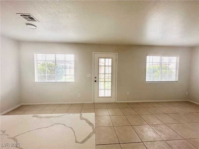 doorway to outside featuring plenty of natural light, visible vents, and a textured ceiling