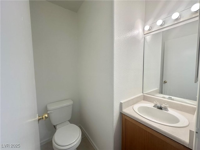 bathroom with toilet, baseboards, and vanity