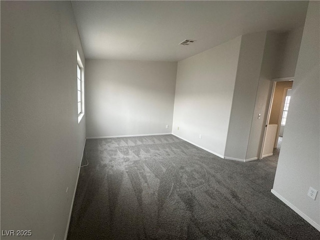 empty room with plenty of natural light, carpet flooring, and visible vents