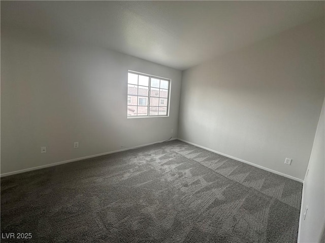 carpeted spare room featuring baseboards