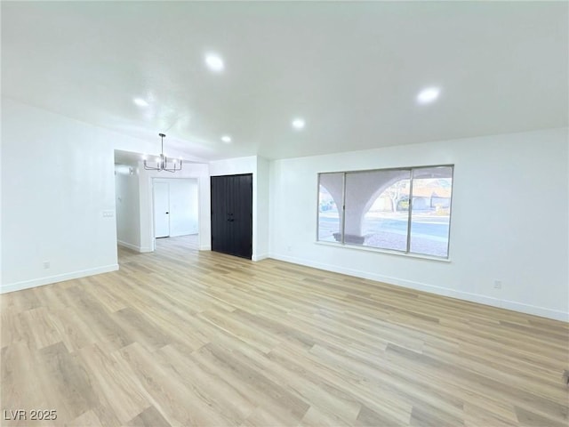 unfurnished living room featuring light hardwood / wood-style floors and a notable chandelier