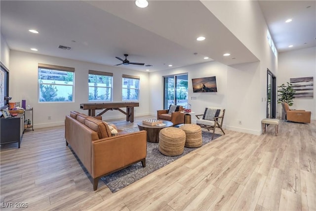 living room with ceiling fan and light hardwood / wood-style flooring