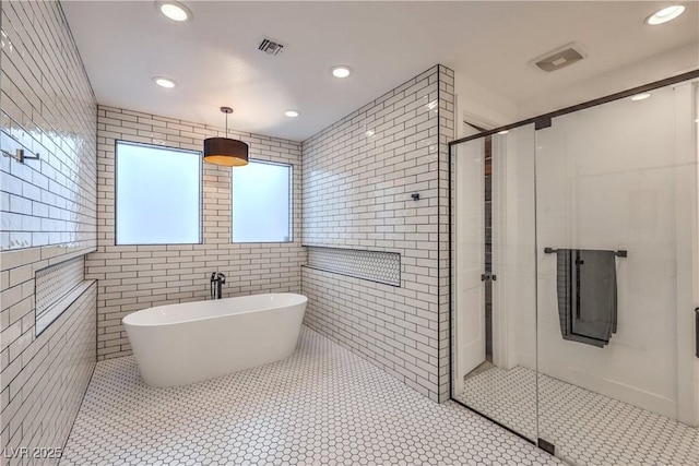 bathroom with tile patterned flooring, shower with separate bathtub, and tile walls