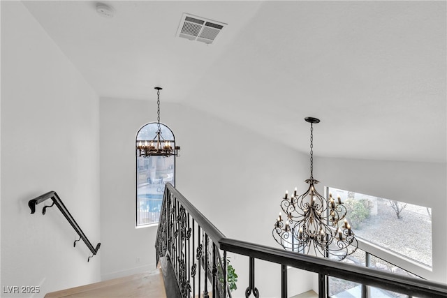 room details featuring a wealth of natural light, a notable chandelier, and lofted ceiling