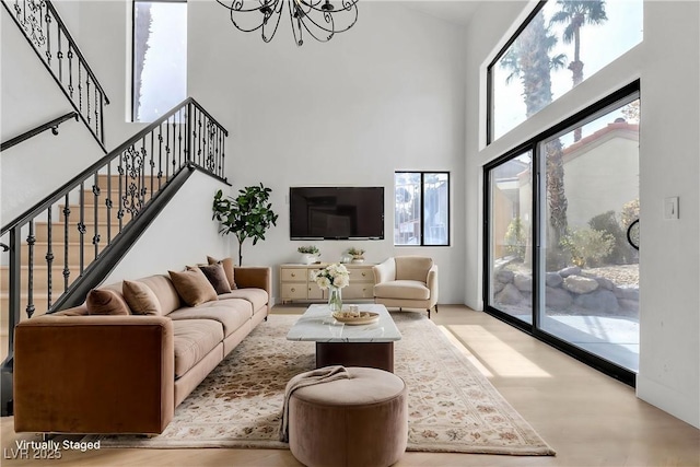 living room with an inviting chandelier and a towering ceiling