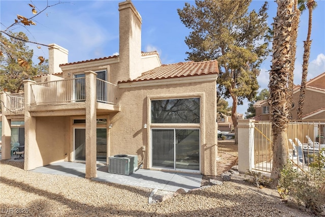 rear view of house featuring central air condition unit, a balcony, and a patio area