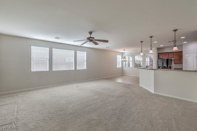 unfurnished living room featuring light colored carpet and ceiling fan