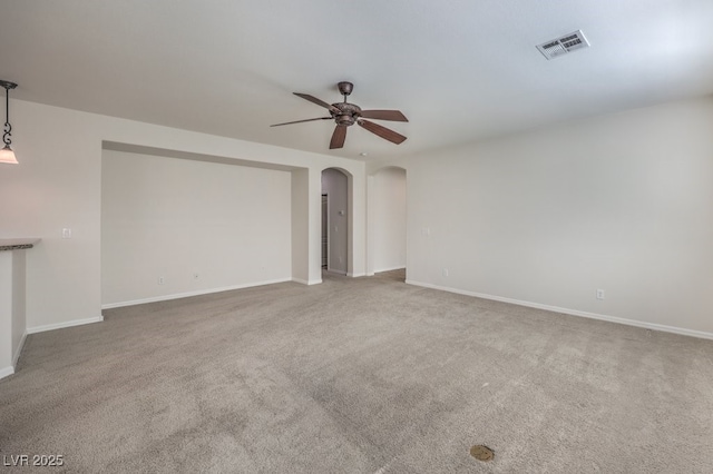 unfurnished living room featuring carpet and ceiling fan