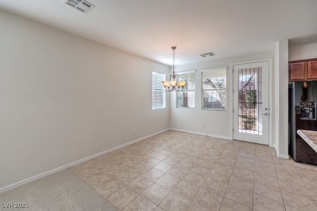 unfurnished dining area with an inviting chandelier and light tile patterned floors