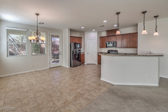 kitchen featuring pendant lighting, kitchen peninsula, dark stone counters, and black appliances