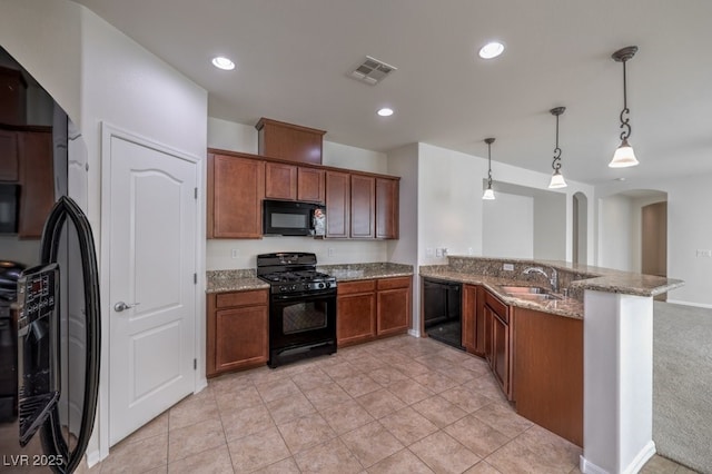 kitchen featuring pendant lighting, sink, black appliances, and kitchen peninsula