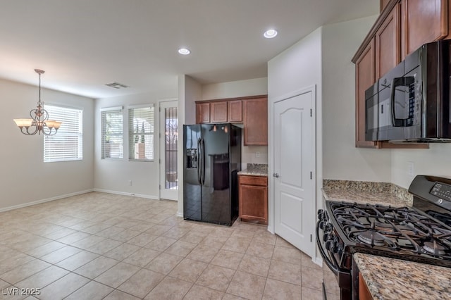 kitchen featuring an inviting chandelier, light stone countertops, light tile patterned floors, and black appliances