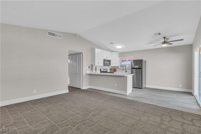 kitchen featuring appliances with stainless steel finishes, sink, lofted ceiling, and ceiling fan