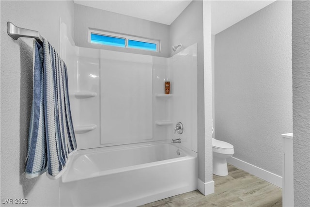 bathroom with hardwood / wood-style floors, toilet, and shower / bath combination